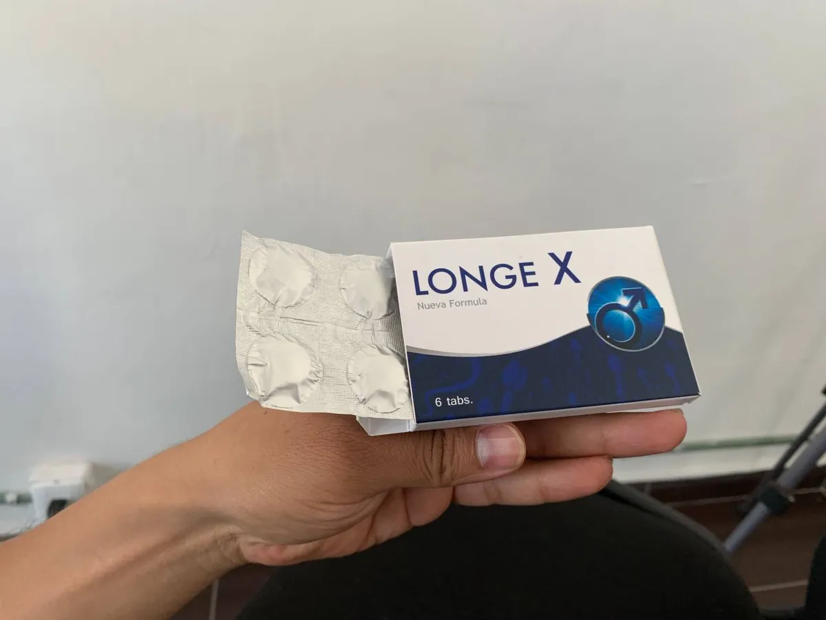 Caja de Longe X abierta en la mano, con el blíster asomando